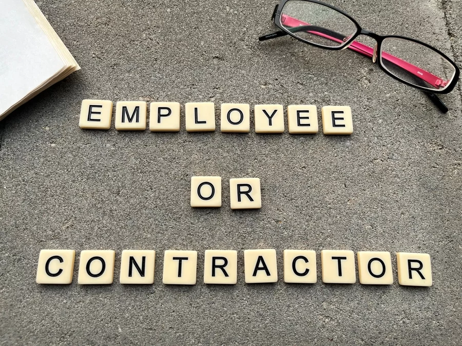 Scrabble tiles spell out 'Employee or contractor.'