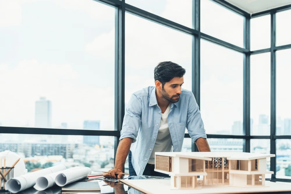 Architect measuring and inspecting house model
